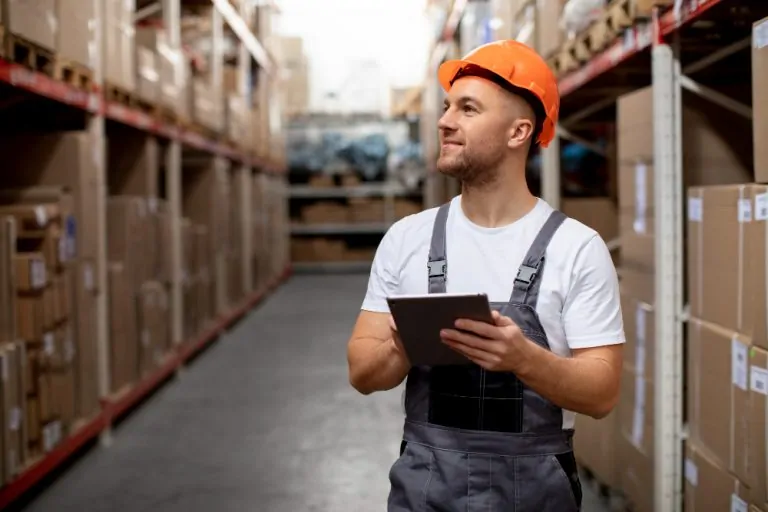 Warehouse worker using a digital tablet to manage inventory and optimize 3PL logistics operations.