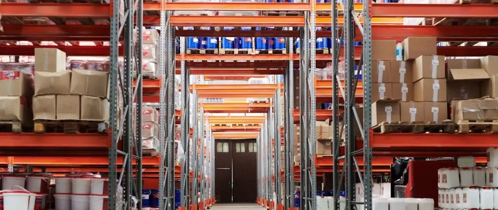 Organized warehouse storage with stacked boxes and containers on industrial shelving racks